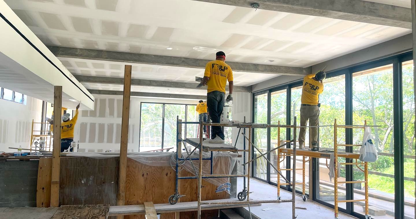 RE&P Florida crew finishing drywall on a South Florida job site